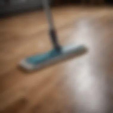 A detailed view of a person using a microfiber mop on hardwood flooring